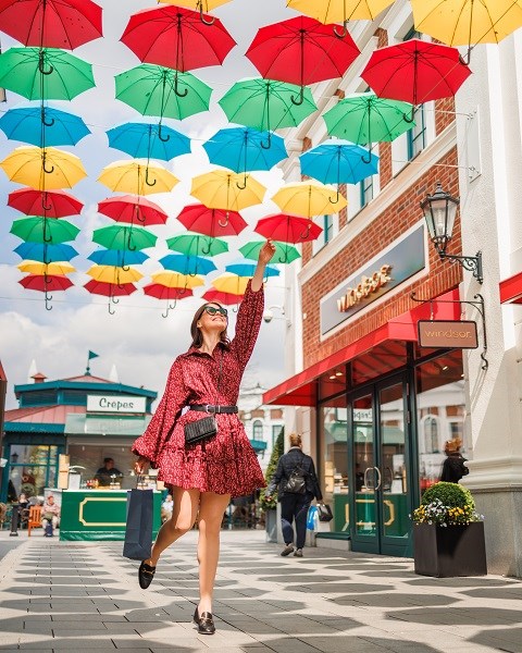  A woman under colorful umbrellas at the Designer Outlet Neumünster