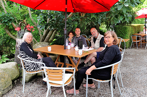 A family with grandparents takes a break at Café Klokkeblomst in Birkegårdens Haver