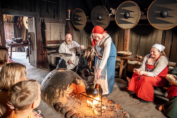 A housewife prepares a meal for her family over an open fire in Bork Vikingehavn