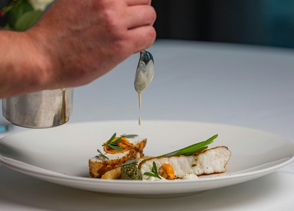 With practiced hands, the chef elegantly plates a dish