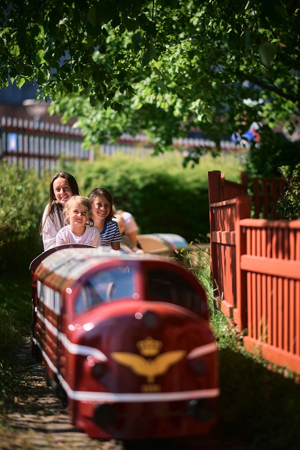 A family is riding the mini train at the Danish Railway Museum