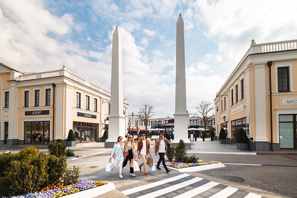 Four young people with shopping bags at the Designer Outlet Neumünster