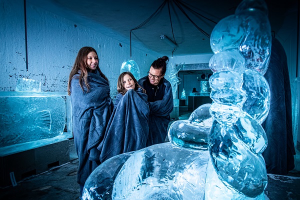 A mother and her two daughters look at works of ice art at the museum Iskunsten