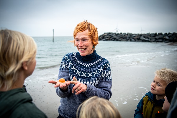 An amber safari guide shows several children a large piece of amber