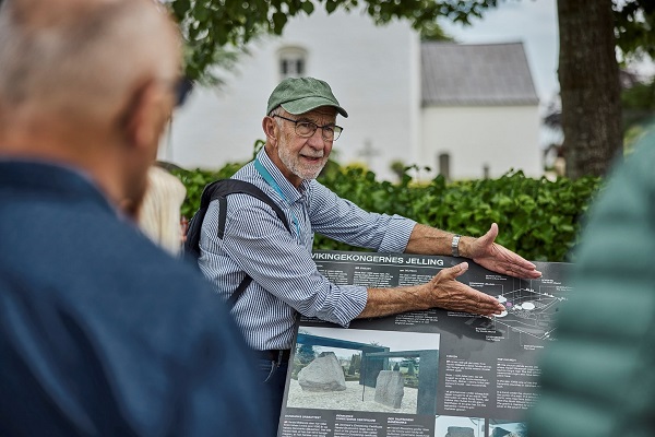 A guide shows the World Heritage poster at Museum Kongernes Jelling