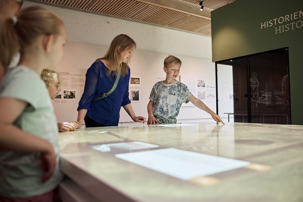 A family looks at the digital displays in Museum Kongernes Jelling