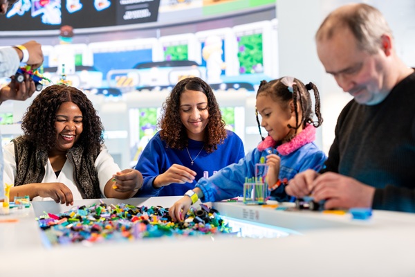 A family is building with LEGO® bricks in the LEGO® House