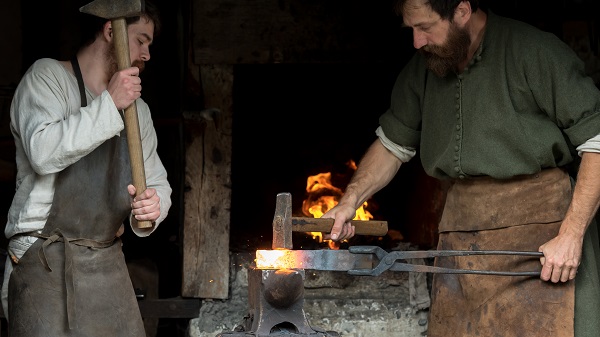 Two blacksmiths from the Middle Ages at work